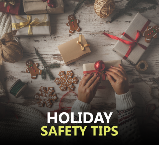 Person tying a bow around a present surrounded by holiday treats and decorations